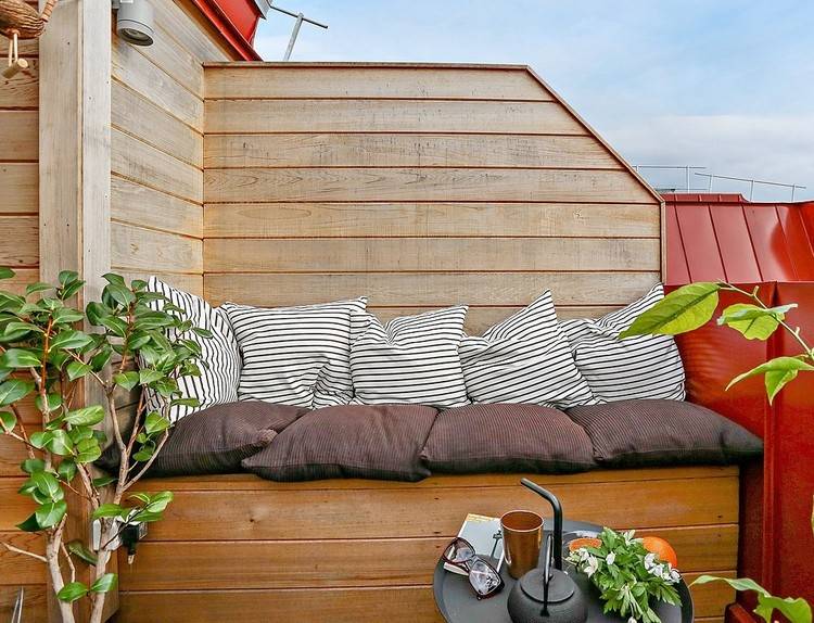 vindskydd-terrass-trä-soffa-kuddar-växter-litet bord
