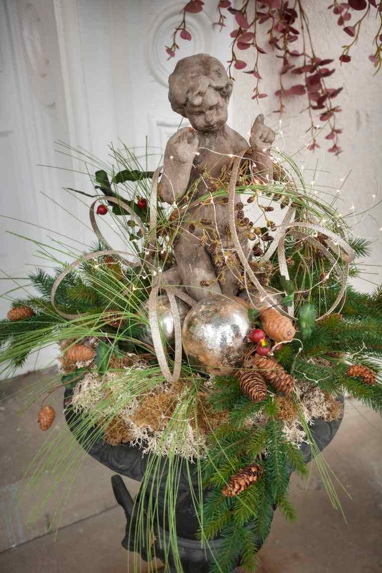 Gör vinterdekorationer till husets entré själv Apmhora växter ängelfigurer av sten och gyllene julgranskulor och kottar och halm- och tallgrenar