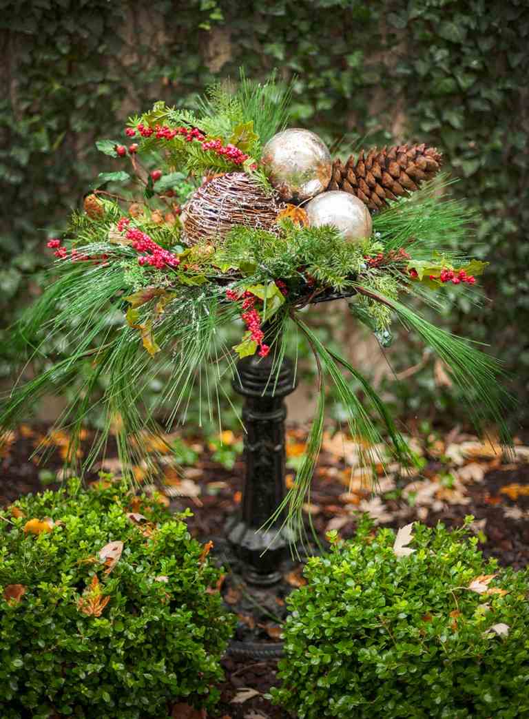 Vinterdekoration trädgårdgranbär ordnar träbollar och gyllene julgranskulor och kottar i trädgården