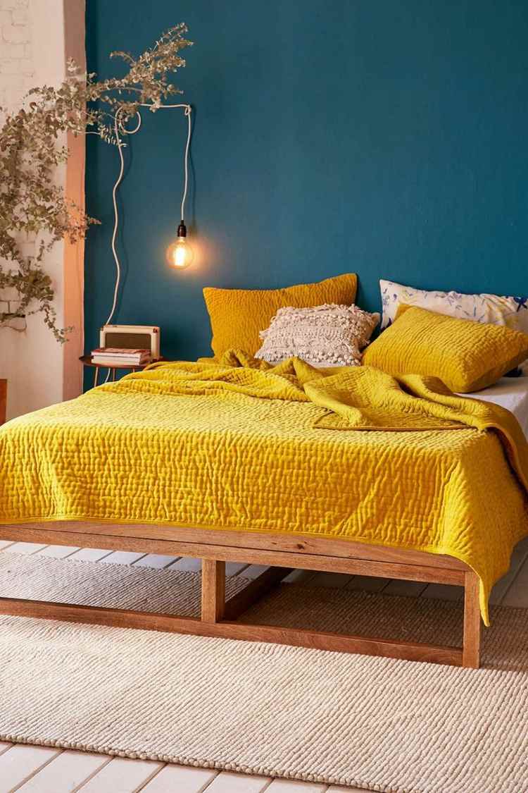 väggdesigntrender bensinblå färg vägg gul sängkläder accent sovrum