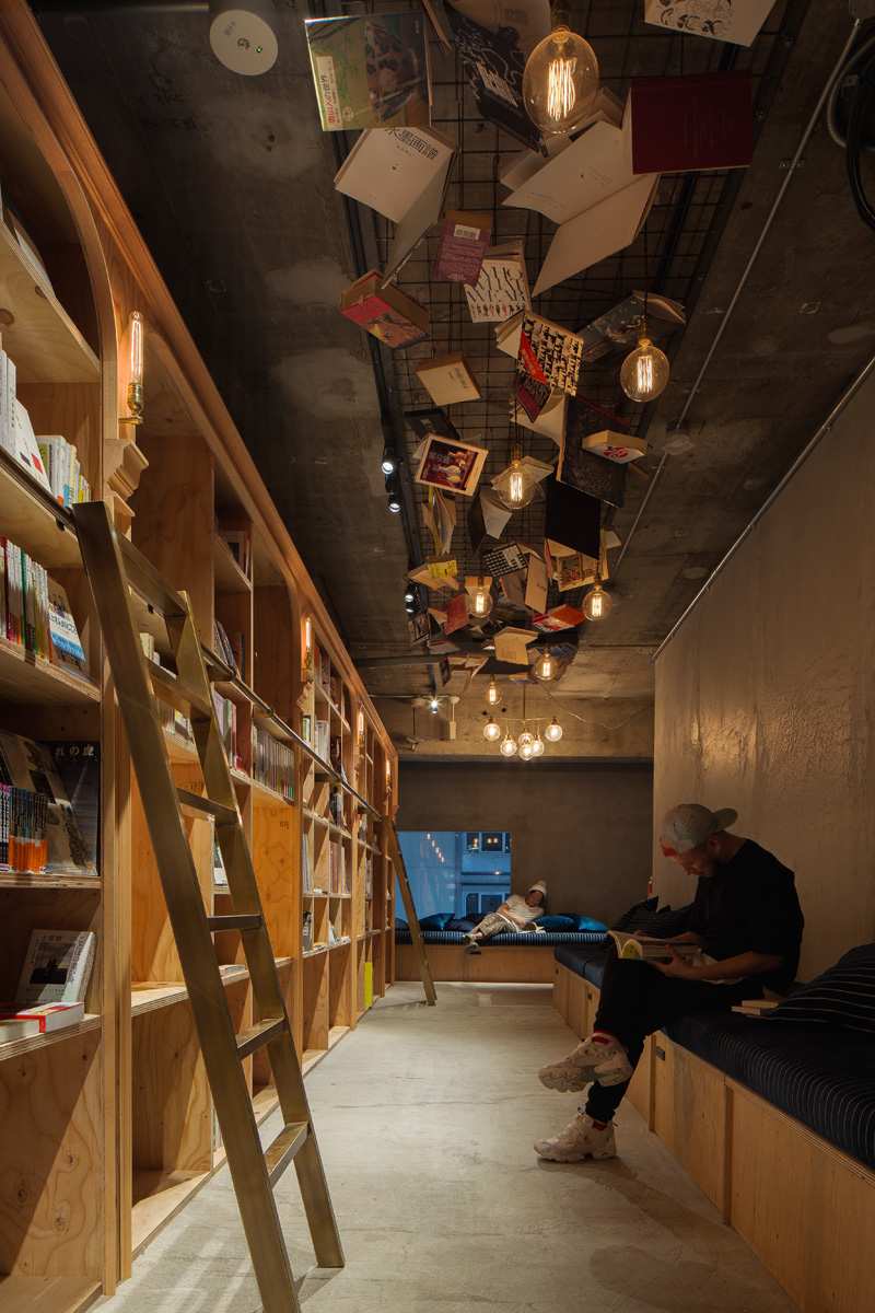 Tillfälligt boende -hostel-tokyo-läs-böcker-moderna-trä-hyllor
