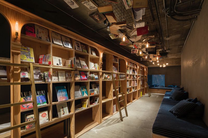 bor-på-tid-vandrarhem-tokyo-böcker-bibliotek-trä-hyllor-liggande-utrymme
