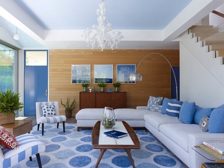 levande-blå-vit-modern-vardagsrum-matta-mönster-cirklar-hörn soffa-kruka ljuskrona-stoppade möbler-trävägg