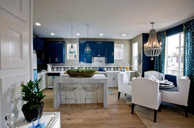 levande-blå-vit-modern-vardagsrum-kristall-ljuskrona-stoppade möbler-trägolv-öppna-kök-fläckar