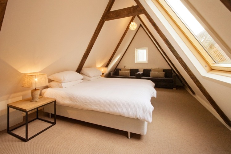 sluttande tak sovrum design enkel balk trä sängbord