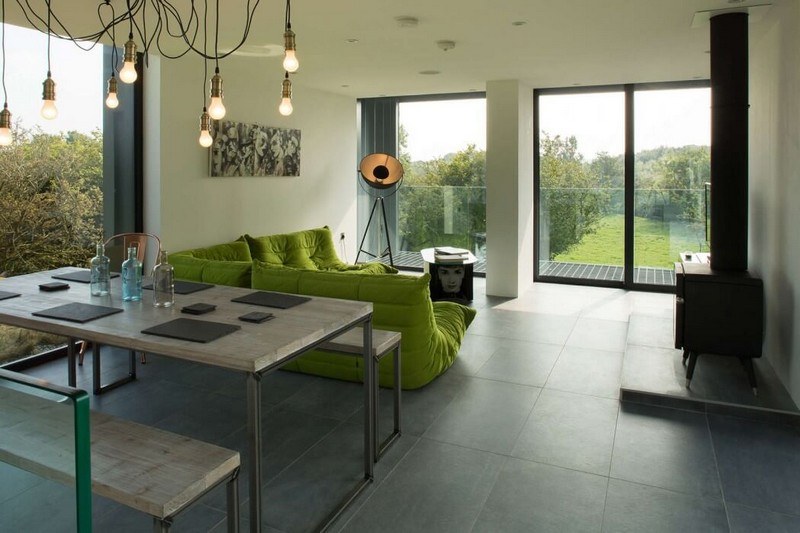 Levande idéer-möbleringsexempel-lime-gröna soffa-granitplattor-öppen spis-skandinaviskt bänkbord