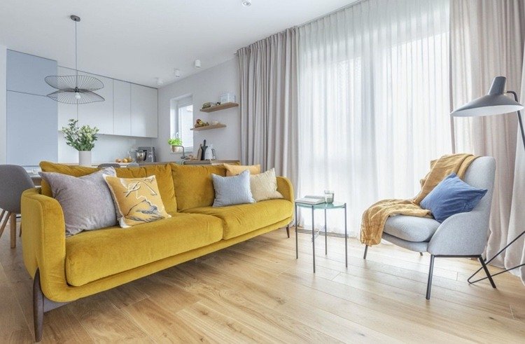 gul soffa som accent i det ljusgråa vardagsrummet