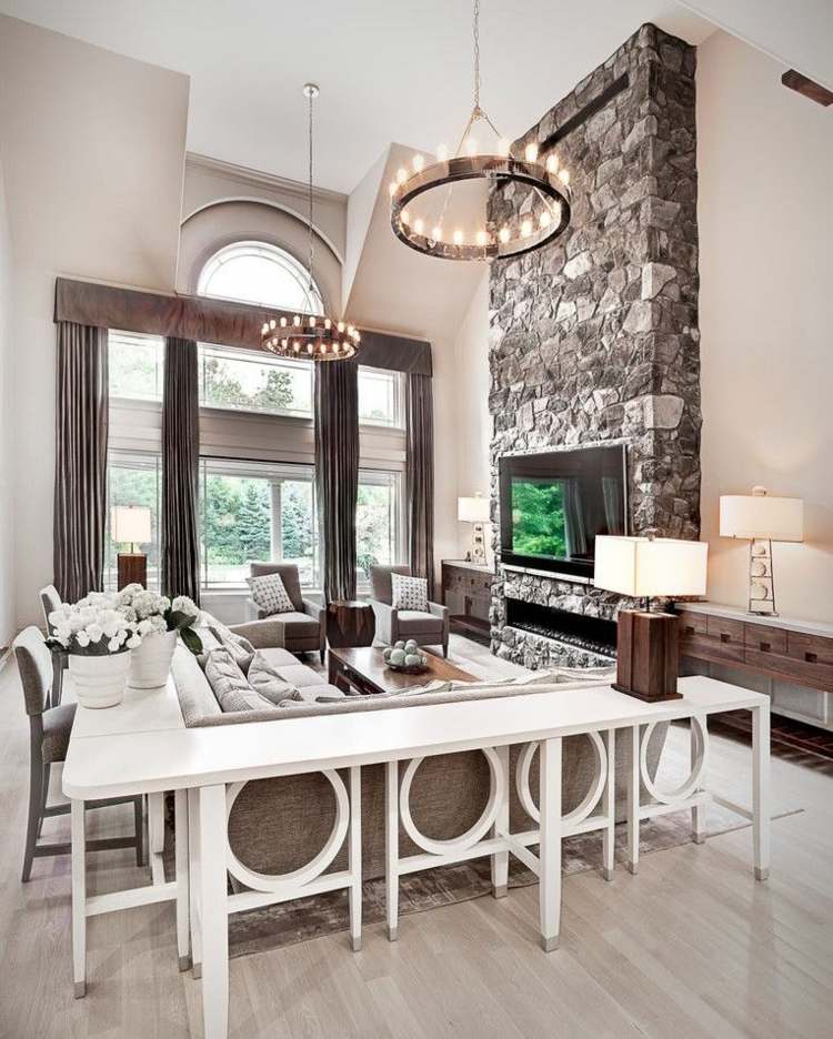 vardagsrum bar krona lampor-bordslampa-hörnsoffa-bord-stolar-öppen spis-väggbeklädnad-stenar-blomkrukor