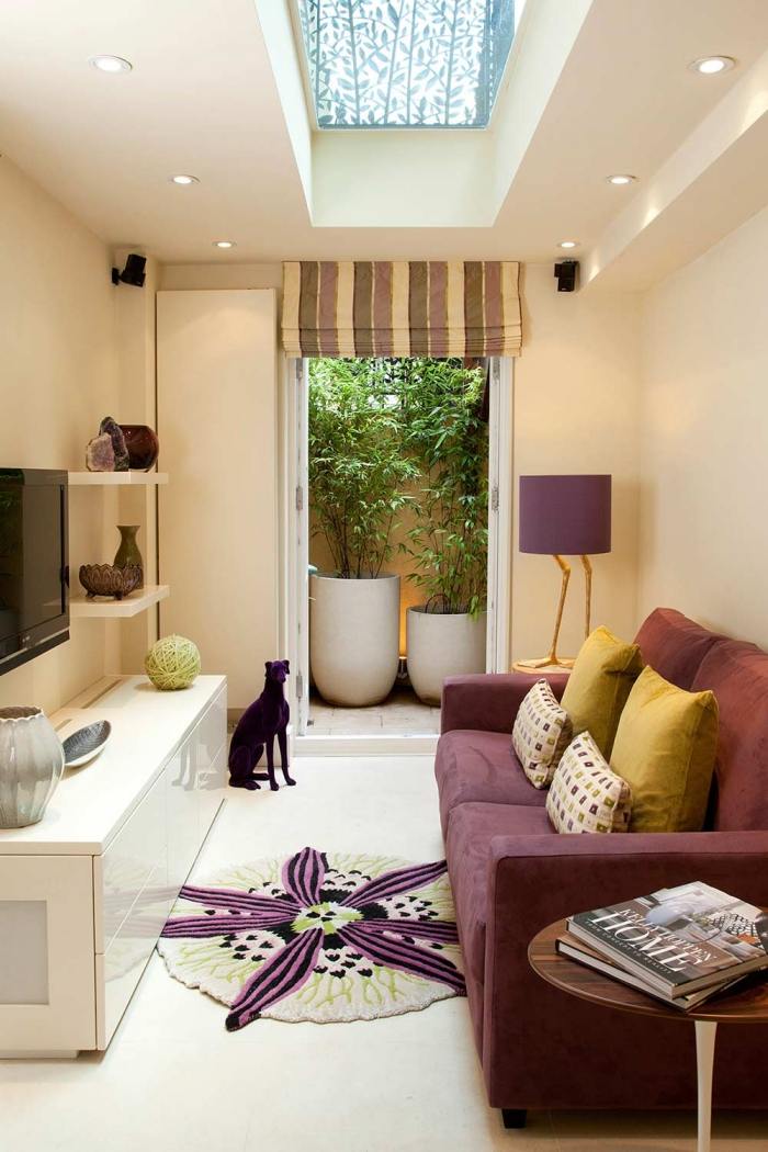 Inredning av ett smalt vardagsrum lila-färgad 2-sits soffa-tv-väggmonterad