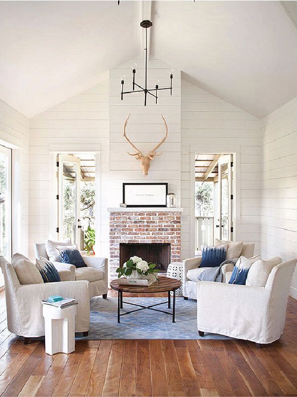 vardagsrum-lanthus-stil-vita-möbler-täcker-planka golv-skorsten-tak