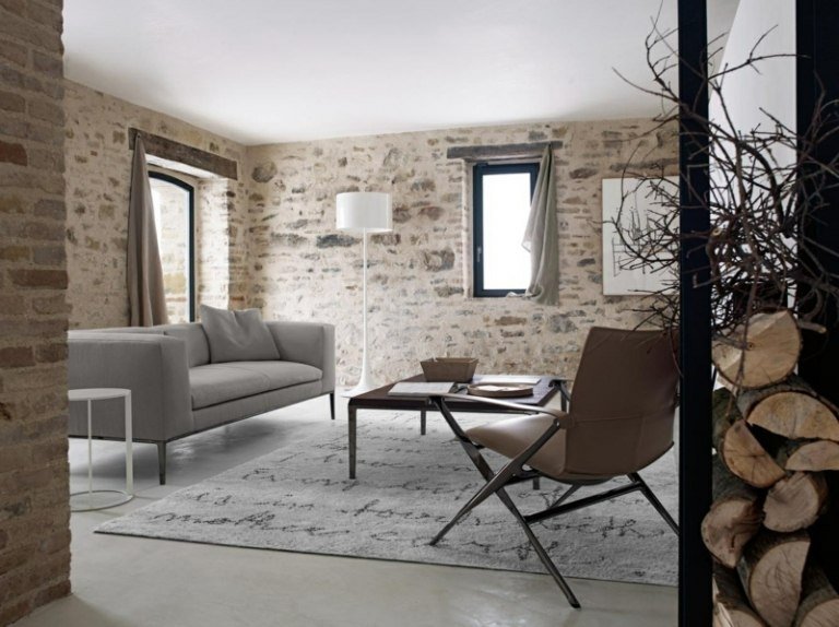 lantlig stil vardagsrum enkel sten vägg soffa stol trä