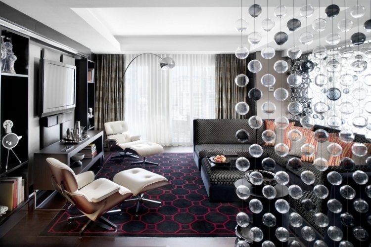 Vardagsrum i grå hörn soffa-matta-fåtölj-eames-vägglampa-arco-glas-pärla-rumsavdelare