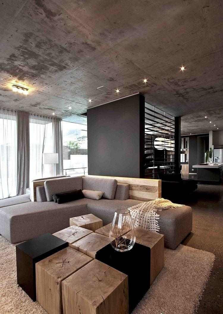 vardagsrum-grå-hörn-soffa-trädstubbe-träblock-soffbord-betong-tak-minimalistisk