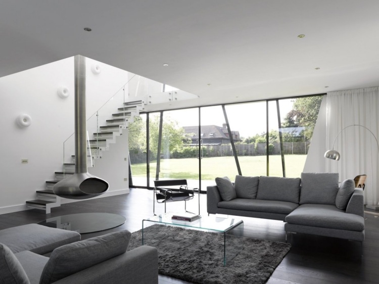 vardagsrum-grå-hörn-soffa-fönster-vägg-spis-lamoe-soffbord-transparent-plastmatta