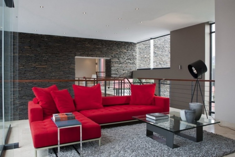 vardagsrum-grå-hörn-soffa-röd-klädsel-soffbord-matta-räcke-väggbeklädnad-sten