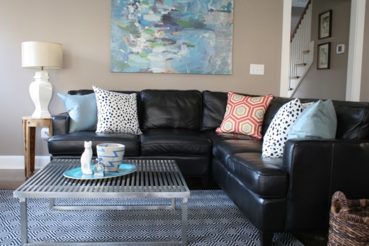 vardagsrum-grå-hörn-soffa-läder-soffa-svart-kudde-mönster-färgglad golvlampa