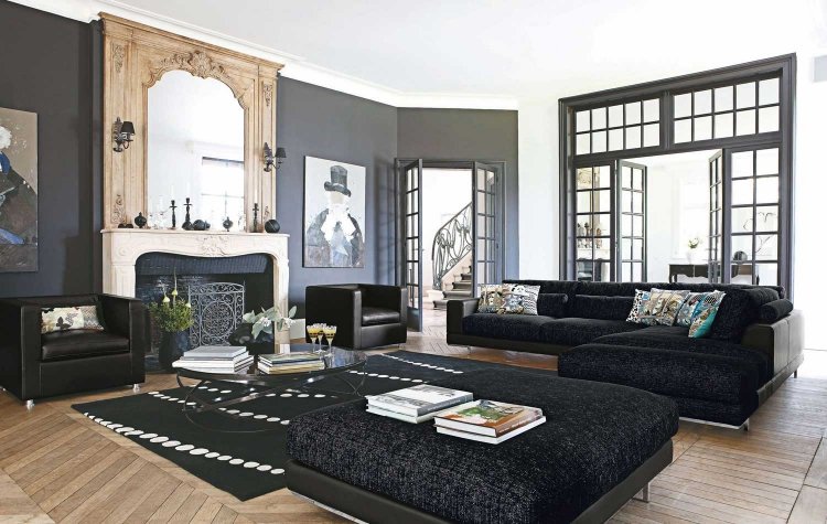 vardagsrum-grå-hörn-soffa-öppen spis-klassisk-ornament-stuckatur-svart-fåtölj-gammal byggnad