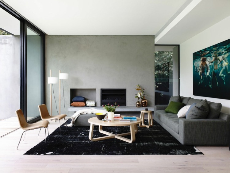 vardagsrumsmattor svart minimalistisk inredning rund soffbord vägg betong utseende