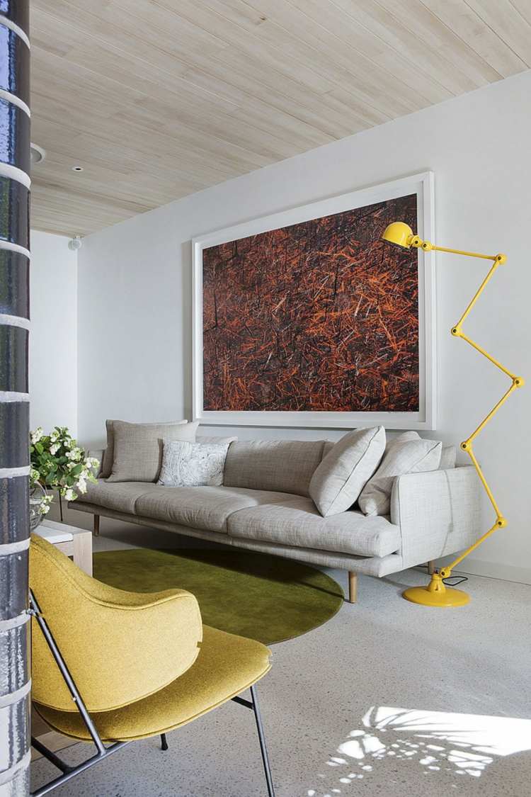 mattor vardagsrum grön rund ljusgrå soffa väggmålning gul golvlampa industriell