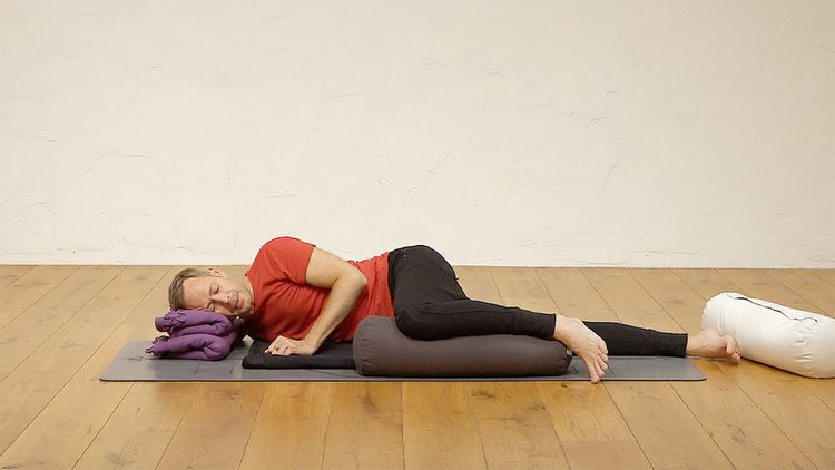 yoga nidra för att somna praktiska övningar för att somna bättre sova djup avslappning man studio ligga sovkudde matta trägolv