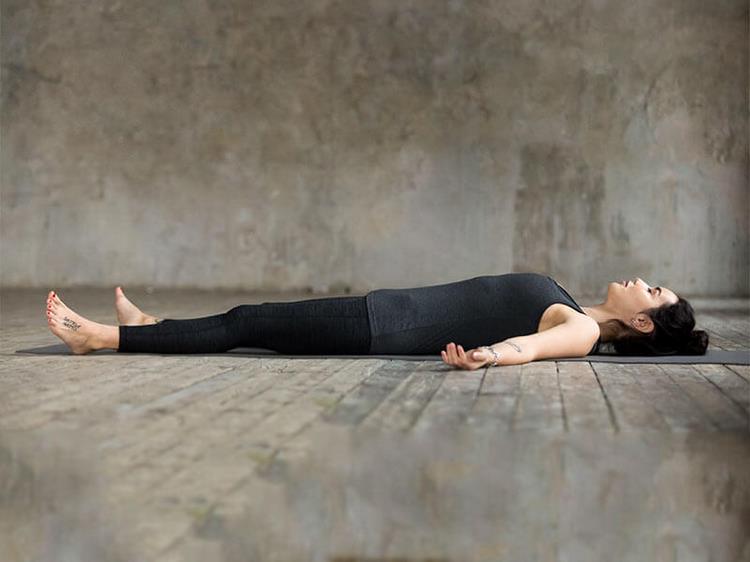 yoga nidra för att somna praktiska övningar för att somna bättre sova djup avslappning kvinna studio ligga sovmatta trägolv
