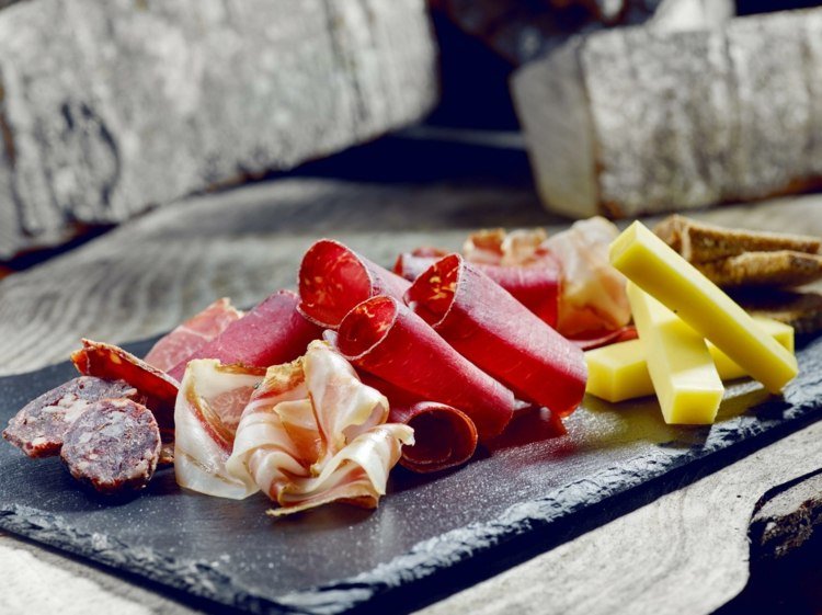 Serverar aperitifbitar av tandpetare salamiost