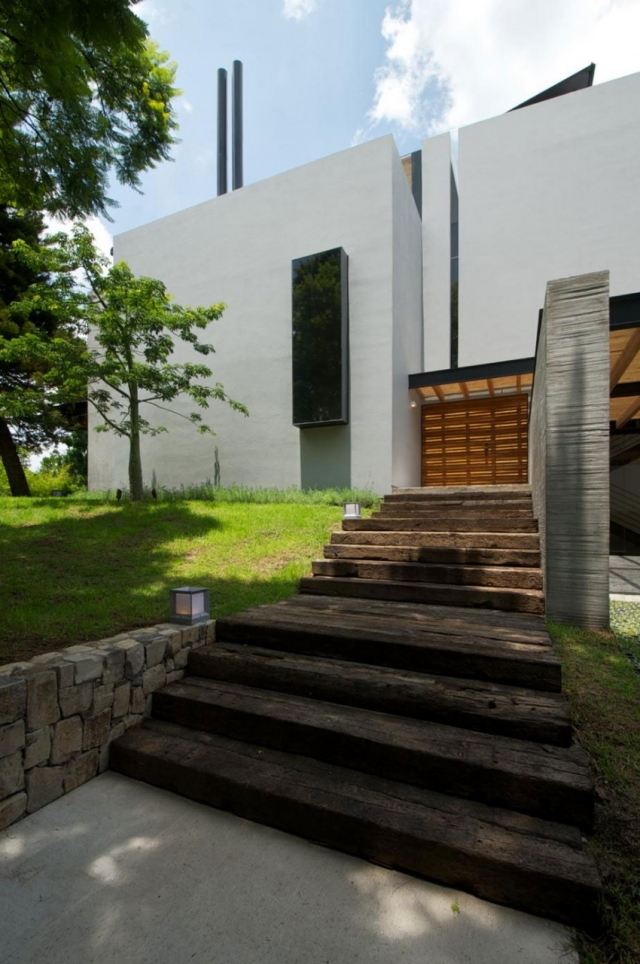 modern-bostad-erbjuder-integritet-sten-trappor-huvudentrén-gräsklippare