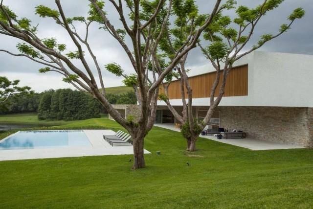 Hus med platt tak-moderna stenklädda fasadträdgårdar