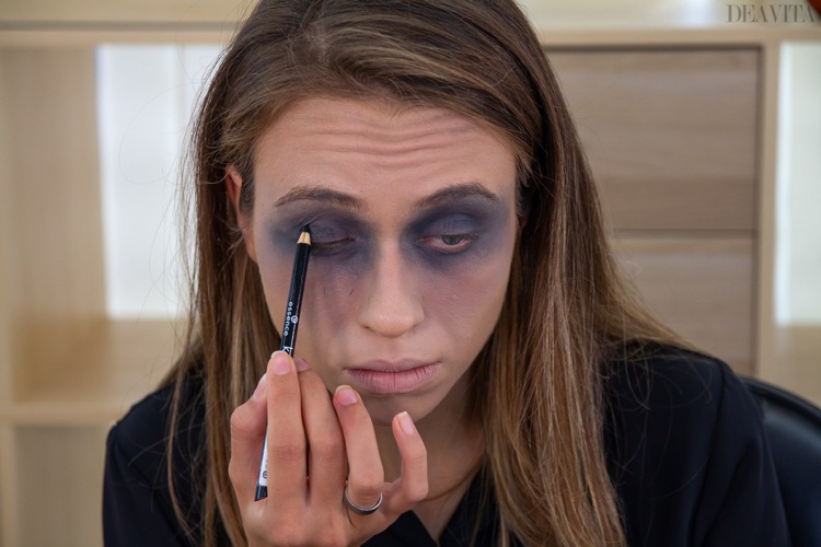 Zombie make-up applicera svart kohl ögonskugga