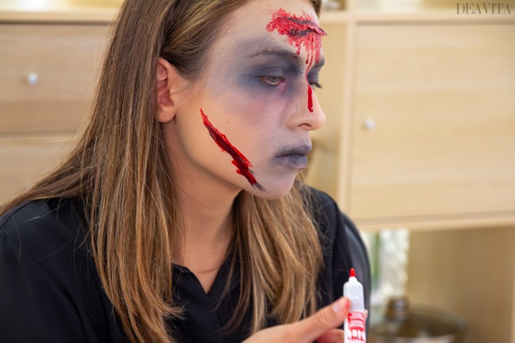 Zombie-smink applicerar falskt blod på kinden