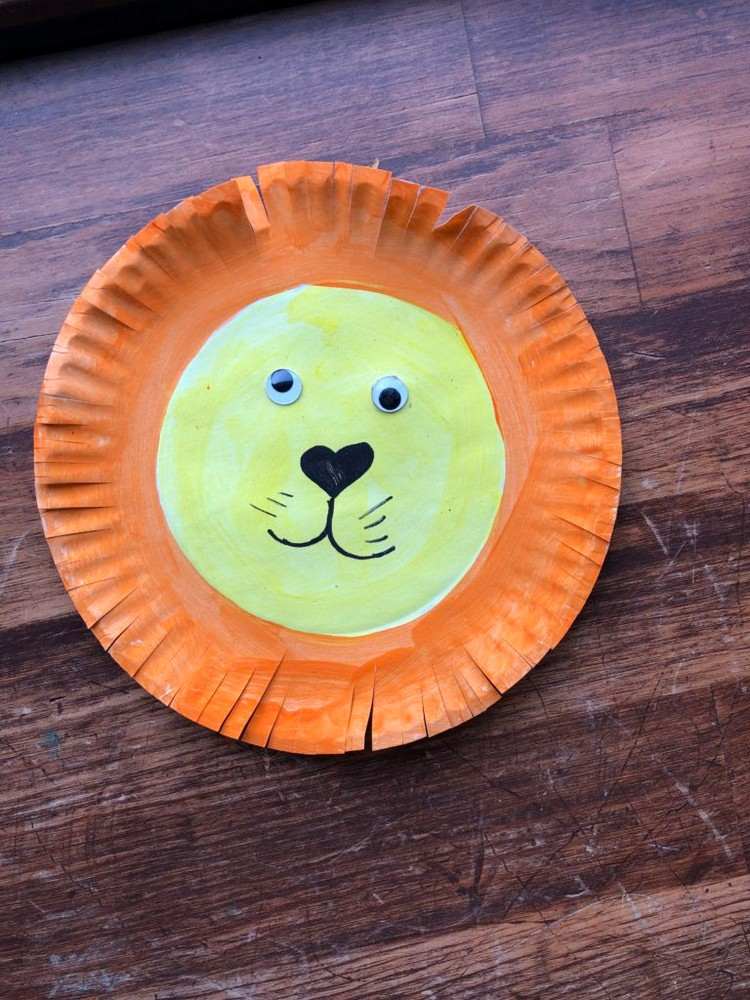 Gör ett lejon för karneval av papperstallrikar med googly ögon