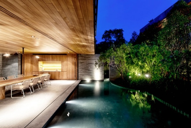 modern arkitektur pool trä tak grönskande vegetation