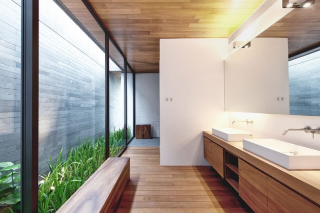 modernt badrum trä badrumsmöbler innergård glasväggar