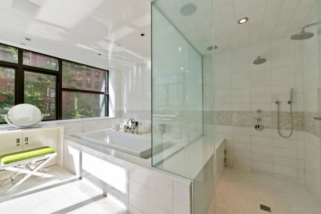 rymligt badrum dusch badkar vit glasvägg